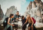 Group of four happy hikers with backpacks and cameras enjoying their adventure near rugged mountain peaks at Mount Roraima.