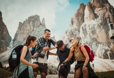 Group of four happy hikers with backpacks and cameras enjoying their adventure near rugged mountain peaks at Mount Roraima.
