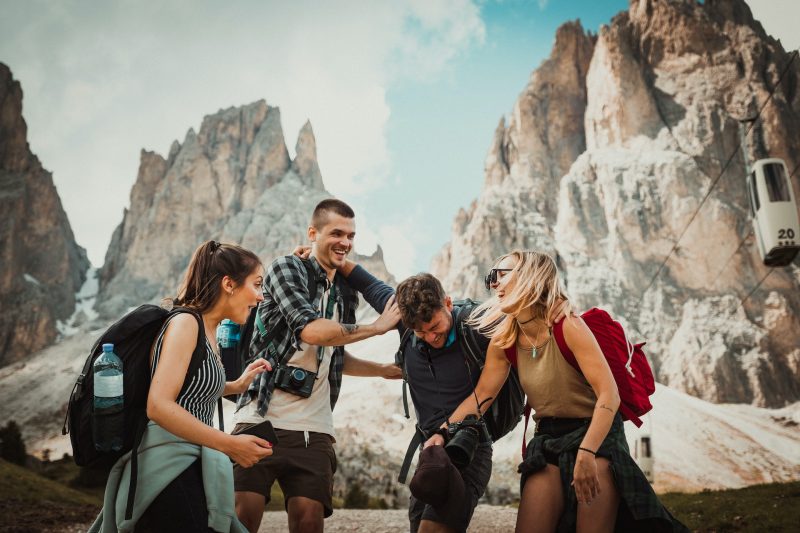 Group of four happy hikers with backpacks and cameras enjoying their adventure near rugged mountain peaks at Mount Roraima.